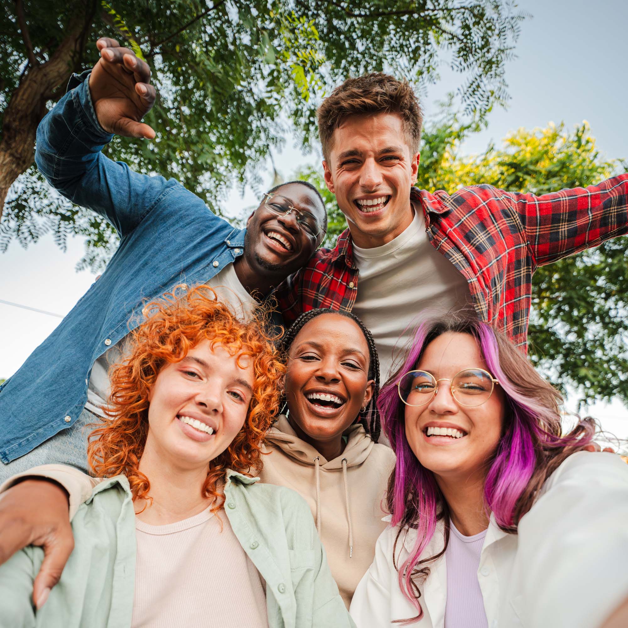 Mehrere Jugendliche als Gruppenbild (Selfie) sind draußen in der Natur und lächeln